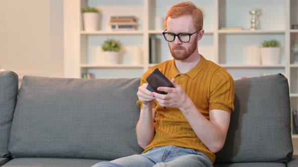 Worried Young Man Checking Empty Pocket for Money at Home