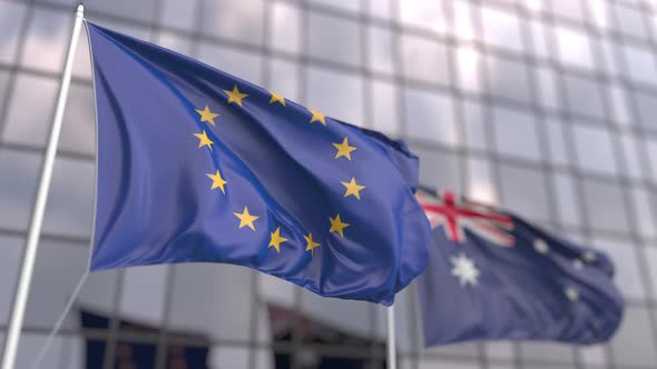 Waving Flags of the EU and Australia Near Modern Skyscraper