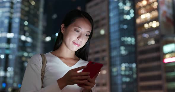 Woman use of mobile phone in city over building background