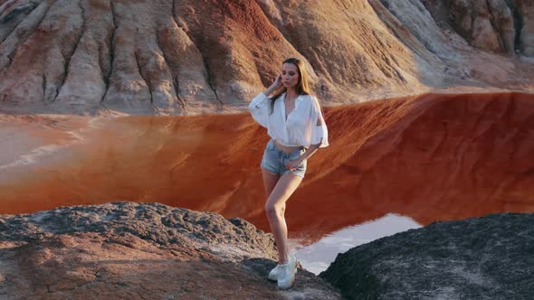 Beautiful woman posing on other-worldly hilly landscape