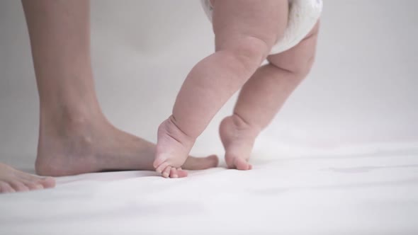 Close-up of a young child's legs learning to walk