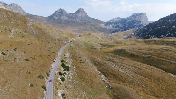 Car driving through Durmitor National Park, Dinaric Alps, Montenegro, drone view