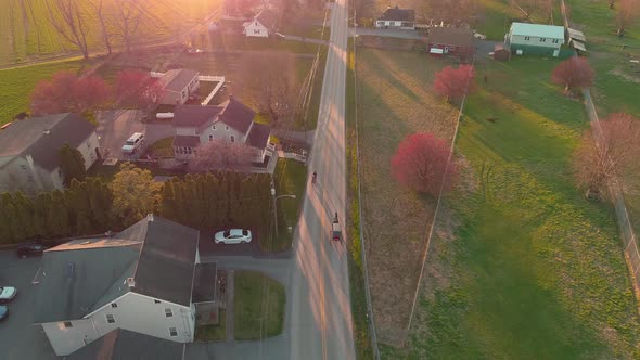 Aerial view of following a horse and buggy in late afternoon