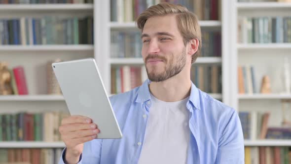 Portrait of Video Call on Tablet By Man in Office