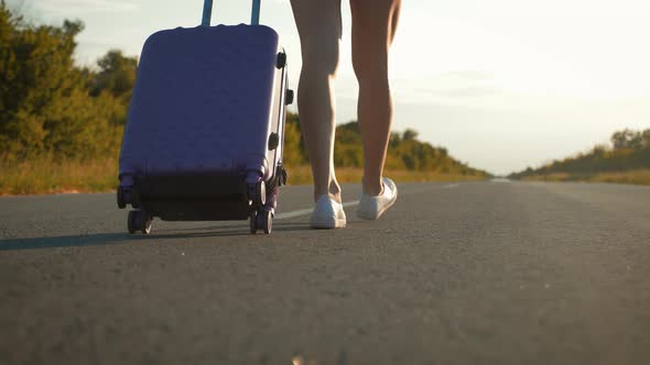 Traveler Woman with Suitcase on Road To Travel. Concept of Travel.