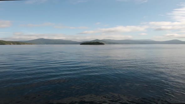 View from a boat on the Malborough Sound. Driving towards a lone island. Near Picton, New Zealand. W