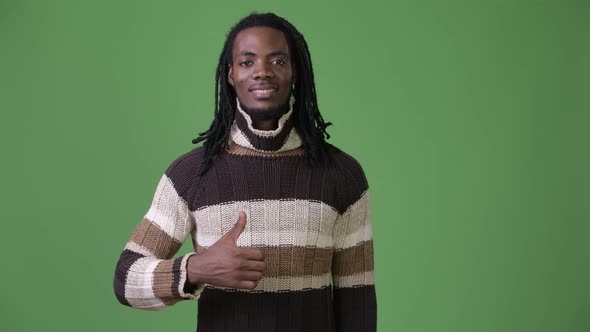 Young Handsome African Man with Dreadlocks Against Green Background