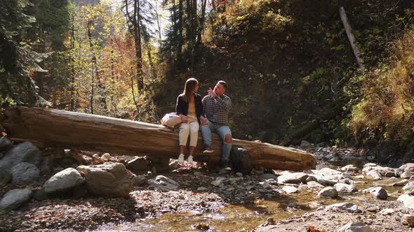 Man with His Girlfriend are Resting in Forest at Fall Day