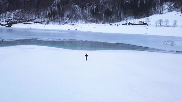 The drone follows a young photographer who is walking through the snow in the Klöntal, Switzerland.