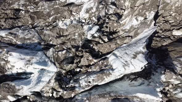 Aerial topdown view of dirty glacier crancks in the Swiss alps