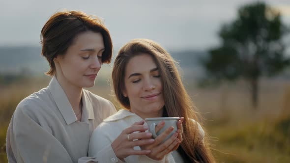 Charming Women Drinking Tea and Talking Outdoors
