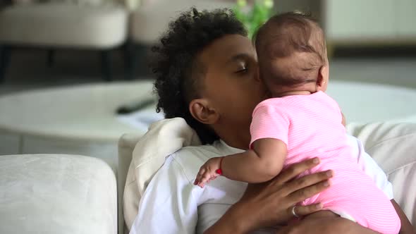 African Boy Kissing Little Sister in White Home Interior Spbd