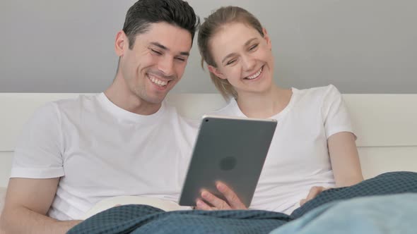 Online Video Chat on Tablet By Couple in Bed