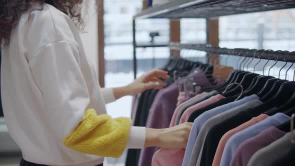 Woman Picks Clothes in a Mall