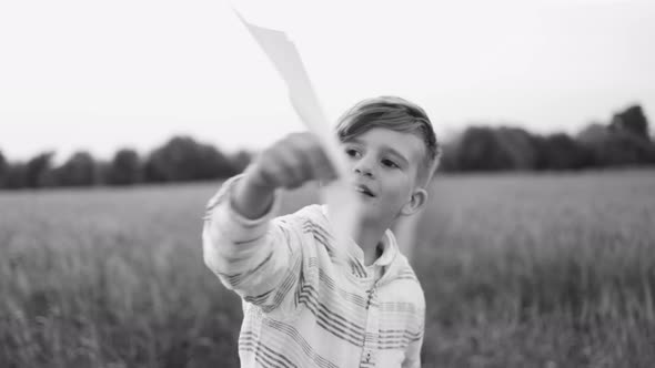 Happy child having fun playing with paper airplane toy outdoor