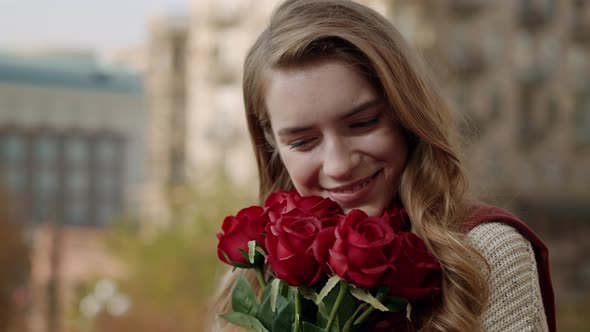 Fancy Woman with Flowers Outdoors. Hipster Girl Enjoying Bouquet on Street.