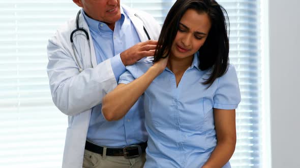 Female patient showing neck pain to doctor