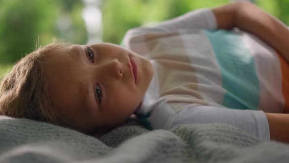 Portrait of Tranquil Boy Lying on Blanket Closeup