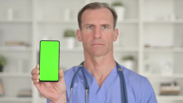 Portrait of Middle Age Doctor Holding Smartphone with Chroma Screen