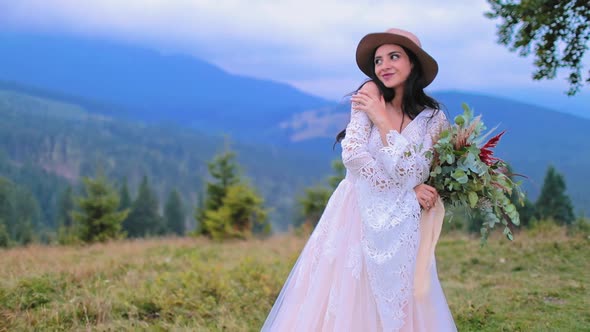 Sexy bride in wedding dress in the mountains