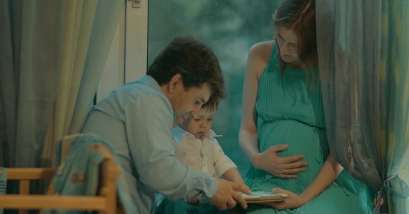Little Boy Holding Tablet And His Parents  alt