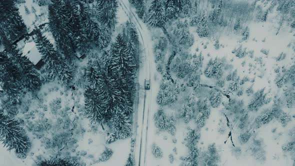 Winter Aerial Footage of a Curved Windy Road Village Cutting Through Mountains Landscape