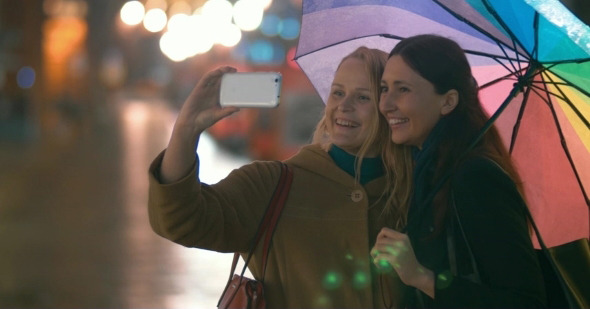 Female Friends Taking Selfie On Smartphone