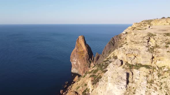 Drone footage of a cliff with pike and sea at morning