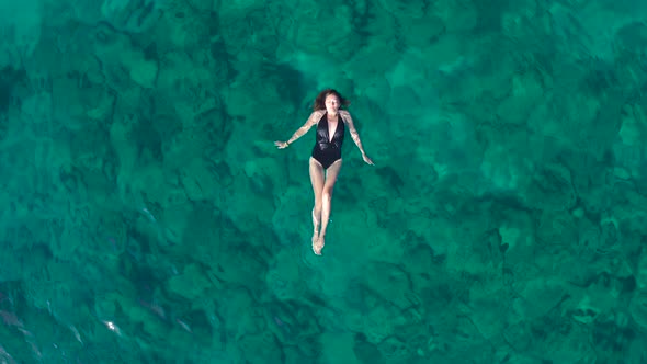 Young Woman Swimming in the Turquoise Sea
