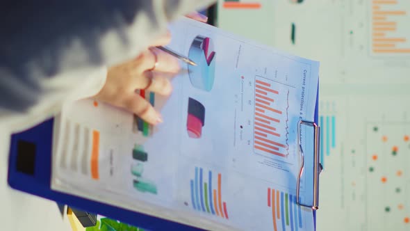 Vertical Video Close Up of Business Woman Holding Clipboard with Graphics