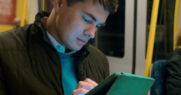Male Passenger With Touch Pad In Subway Train alt