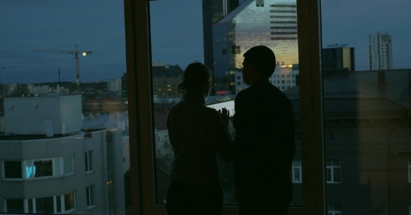 Couple Using Pad And Enjoying View Of Evening City