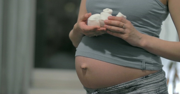 Pregnant Woman's Belly And Baby Booties