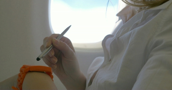 Woman Using Smart Watch In Plane