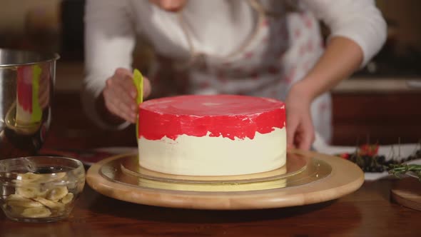 Young Girl Putting Berry Cream on the Cake