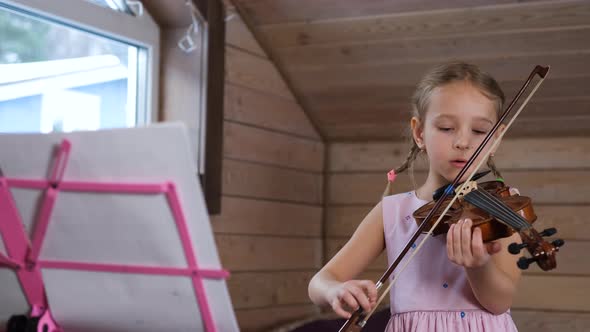 Little Girl Plays Violin and Sings Song at Home