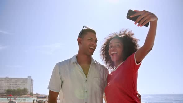 Couple taking selfie with mobile phone at beach promenade 4k