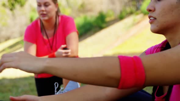 Female trainer instructing women while exercising during obstacle course