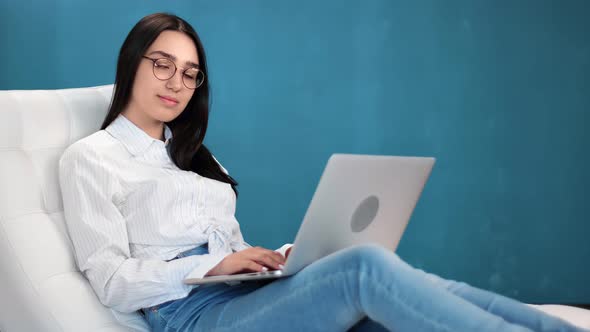 Smiling Mixed Race Woman Posing in Comfy White Armchair with Notebook