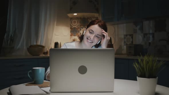 Woman In The Kitchen With Laptop. She Smiles