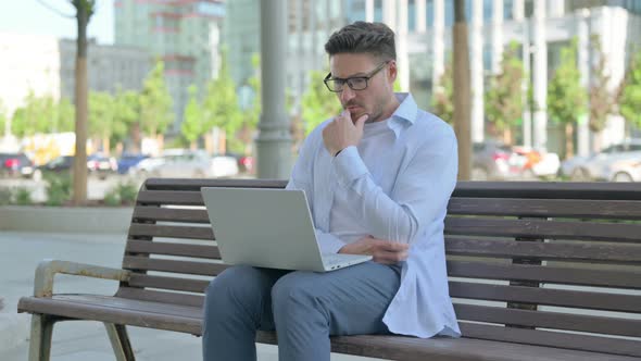 Thinking Man Using Laptop While Sitting Outdoor on Bench