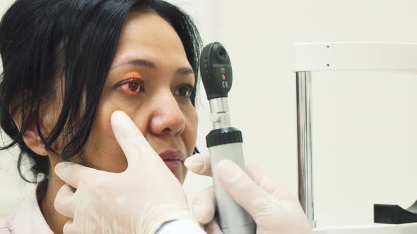 The Clever Doctor Shines a Special Lamp in the Patients Eyes