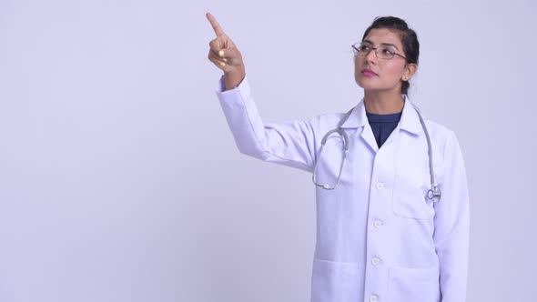 Young Happy Persian Woman Doctor Thinking and Pointing Up