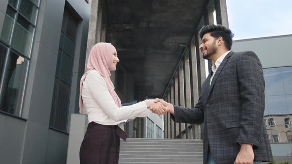 Businessman Woman in Hijab and Muslim Businessman Shaking Hands to Each Other