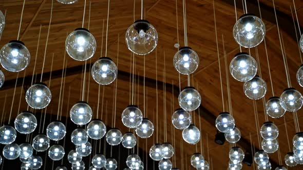 Modern ceiling design. Shining glass balls hanging from the top. Interior of glowing round lamps on 