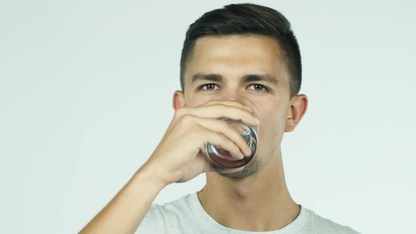 The Young Man Drinks Water From a Glass