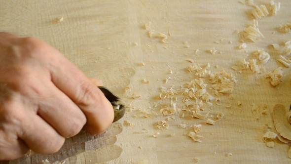 Luthier Sanding a Guitar in Workplace