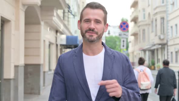 Close Up of Man Talking on Video While Walking Down the Street