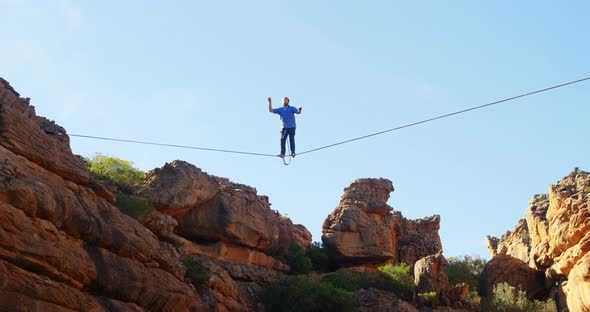 Man falling from slackline in rocky mountains