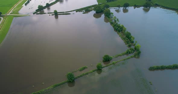 Aerial tilt up view of flooded farmland on floodplains, river Maas, Netherlands.